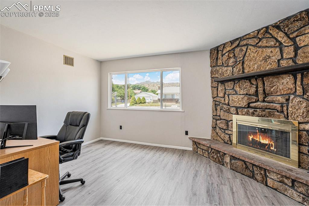 Image 11 of 35: Office space with a stone wood burning fireplace