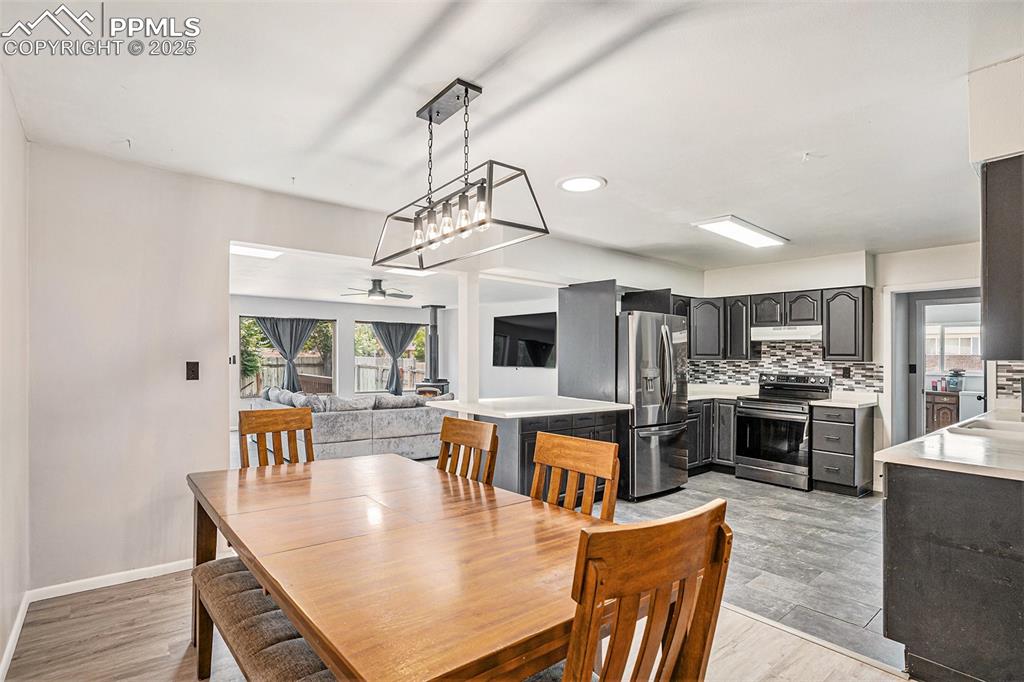 Image 12 of 35: Open concept dining room with new lighting that adjoins to the kitchen.
