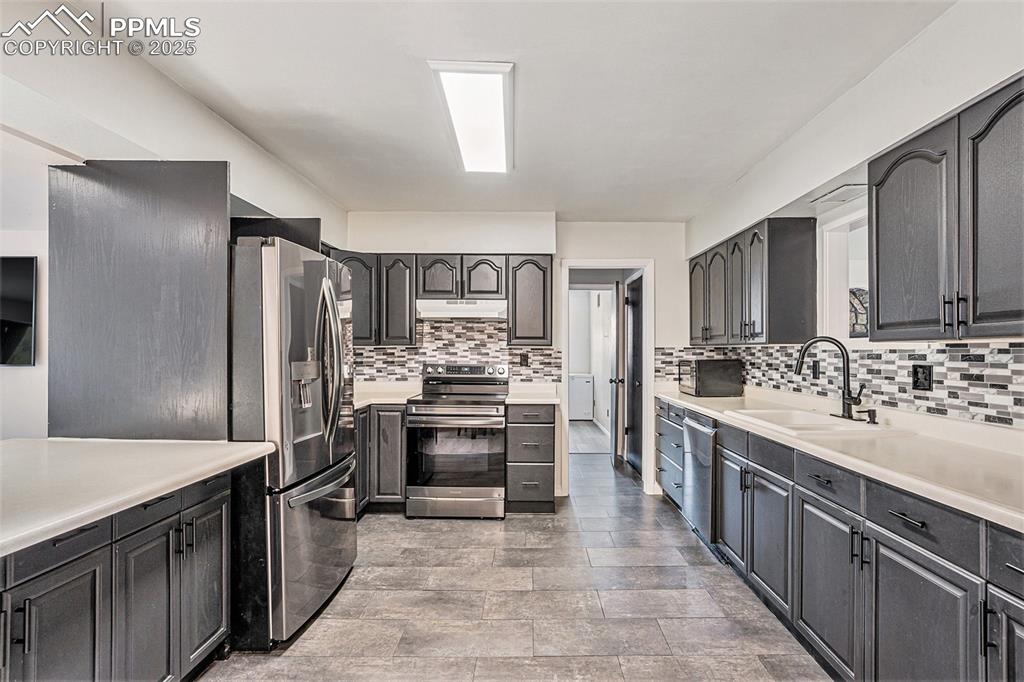Image 14 of 35: Kitchen with appliances with stainless steel finishes, under cabinet range