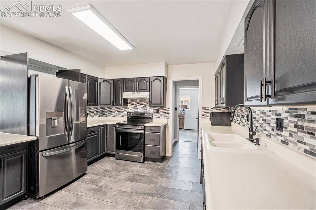 Image 15 of 35: Kitchen featuring appliances with stainless steel finishes, under cabinet r