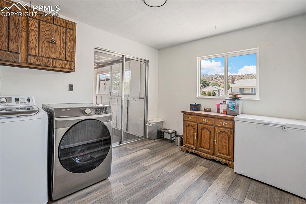 Image 17 of 35: Laundry room with washer and dryer. New flooring, offshoot from kitchen, an