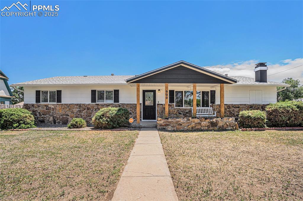 Image 2 of 35: Ranch-style house with a front lawn, covered porch, and stone siding