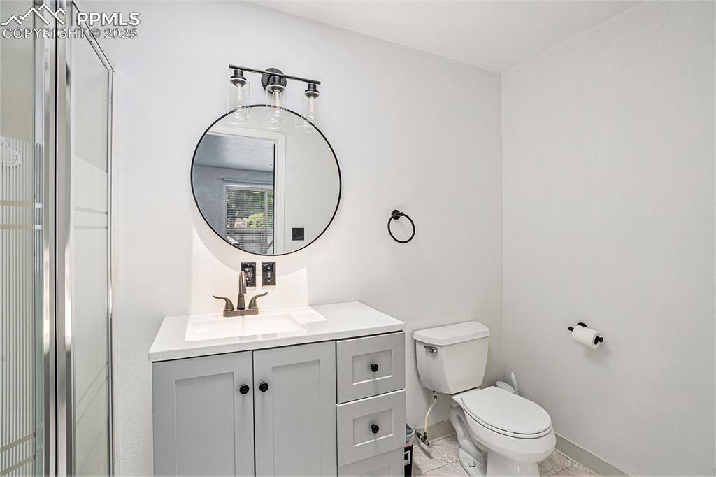 Image 25 of 35: Bathroom featuring vanity and tile flooring, shower stall