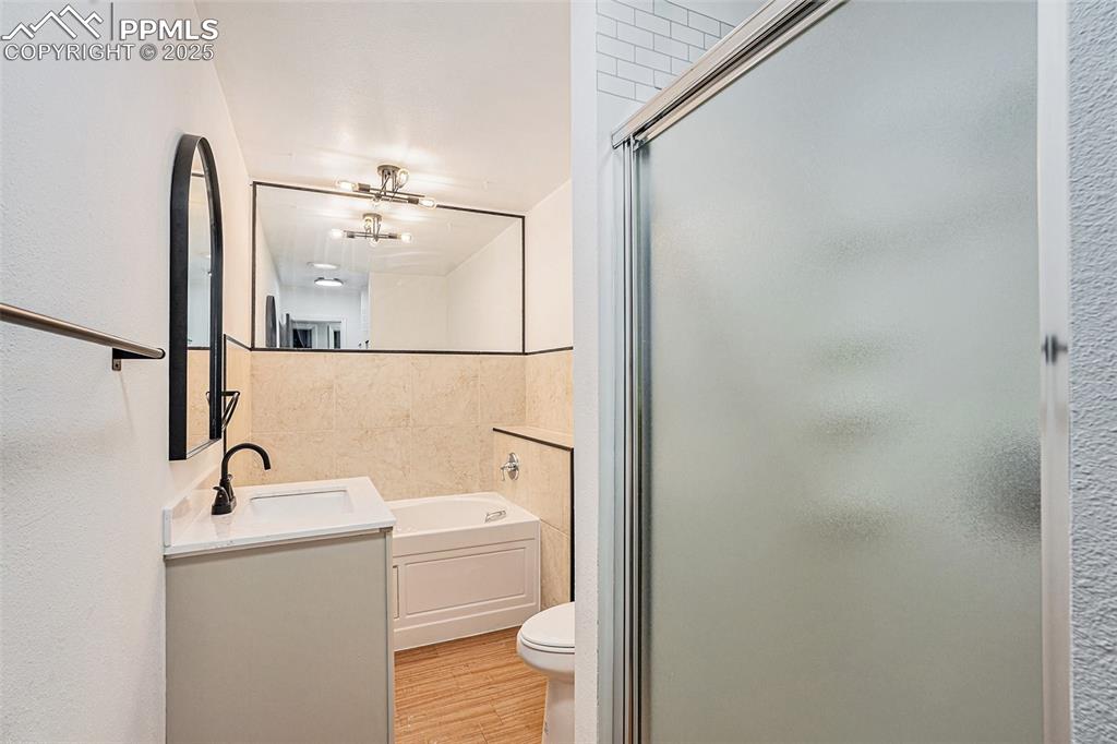 Image 29 of 35: Full bathroom with a shower stall, jacuzzi tub, vanity
