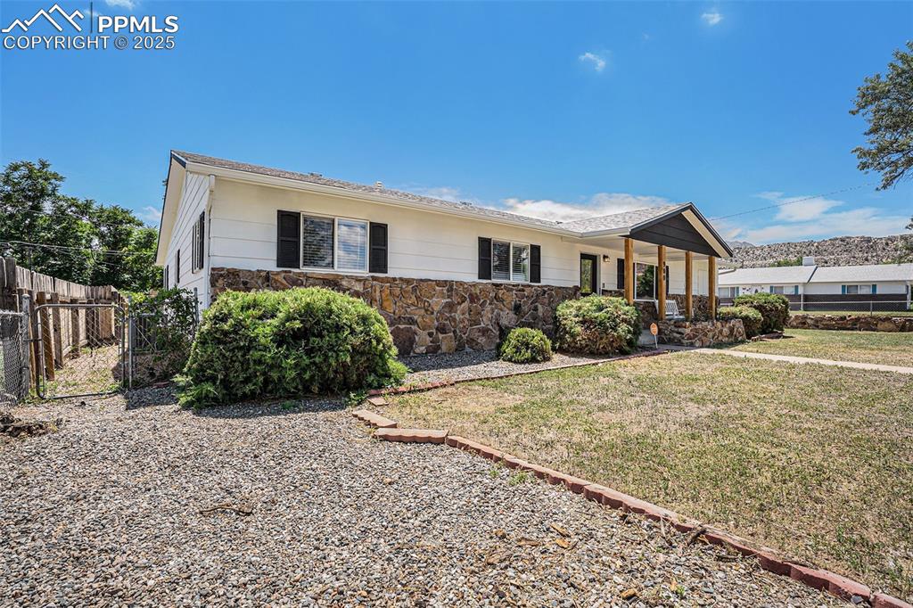 Image 3 of 35: Ranch-style home featuring a porch, stone siding, and a shingled roof