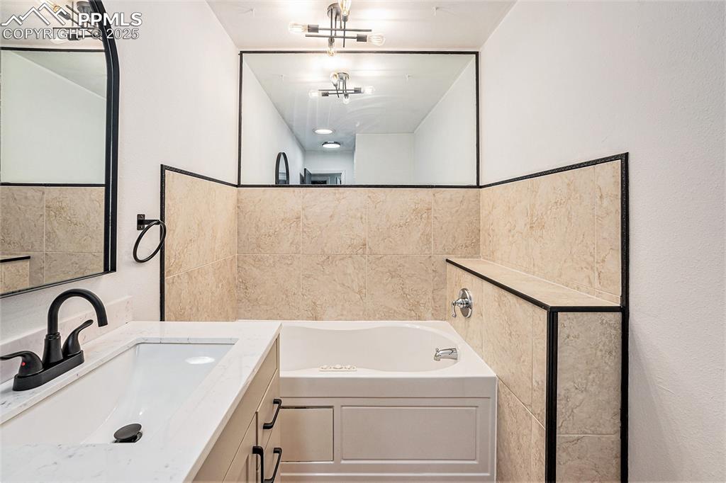 Image 30 of 35: Bathroom with a bath and vanity