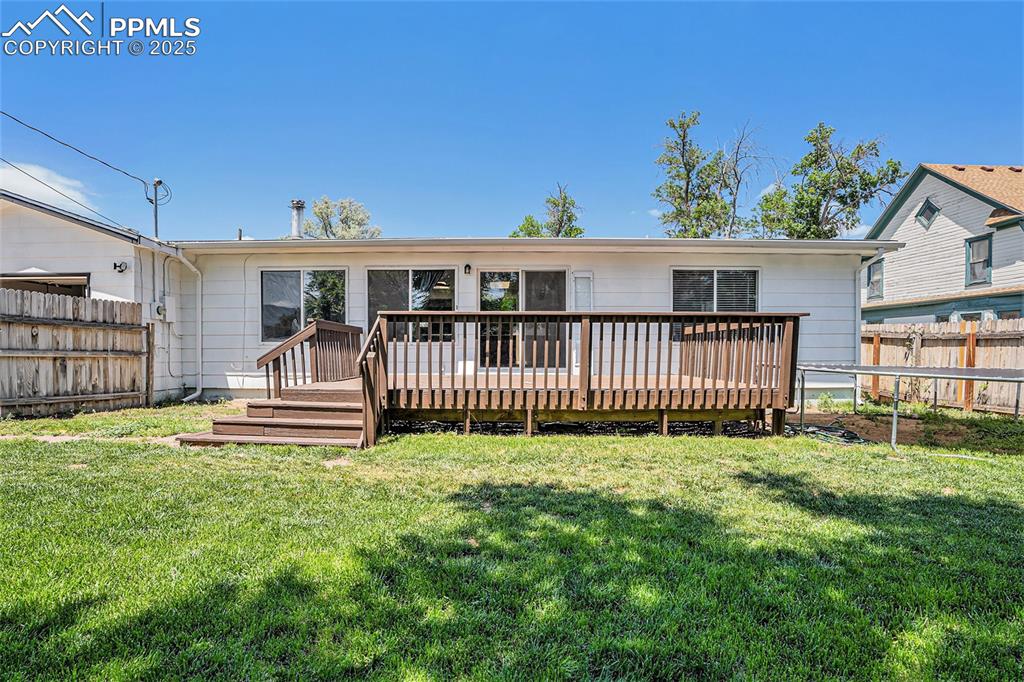 Image 32 of 35: Back of house featuring a fenced backyard and a wooden deck