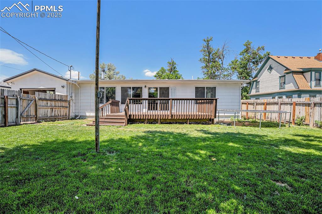 Image 33 of 35: Rear view of property with a fenced backyard and a wooden deck