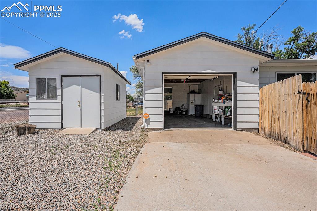 Image 35 of 35: Attached garage with concrete driveway, and storage shed