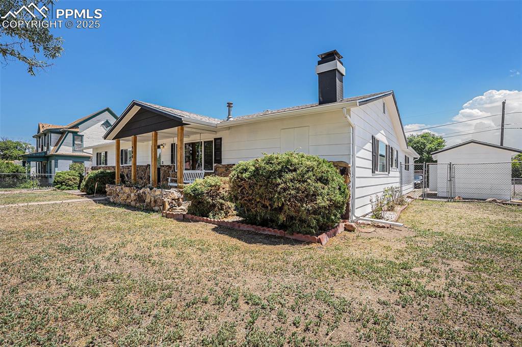 Image 4 of 35: Front of property with a chimney, covered porch, and a gate