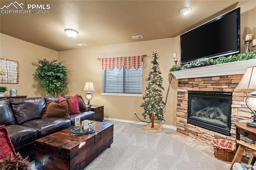 Image 24 of 36: Basement large family room with gas fireplace