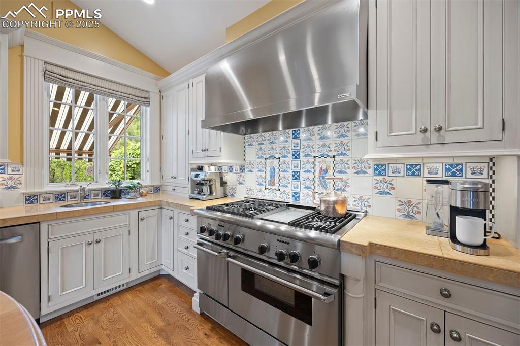 Image 11 of 49: Stunning hand-painted tile backsplash in a William Morris design.