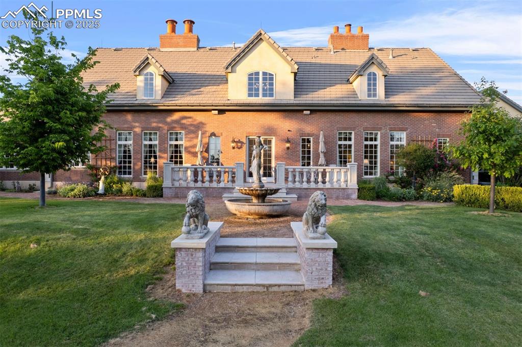 Image 28 of 49: A timeless brick façade and grand balustrade terrace overlook manicured gro