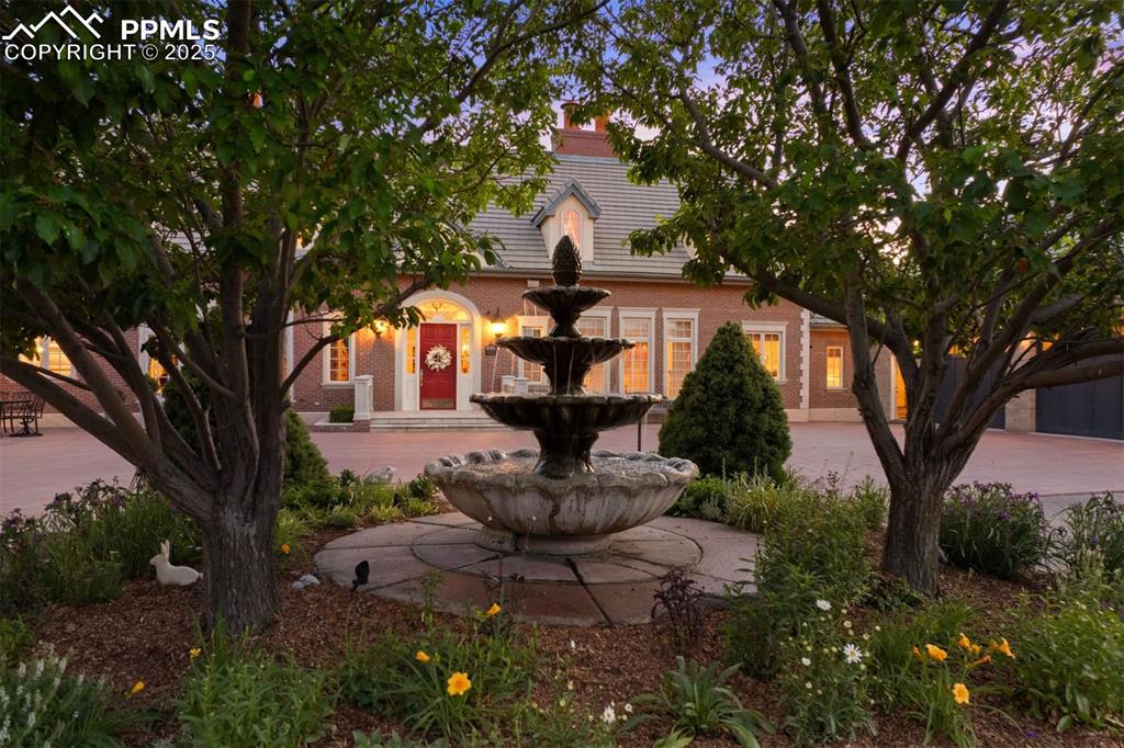 Image 5 of 49: Beautiful, gated entry leads to a circular pavered drive surrounding a land