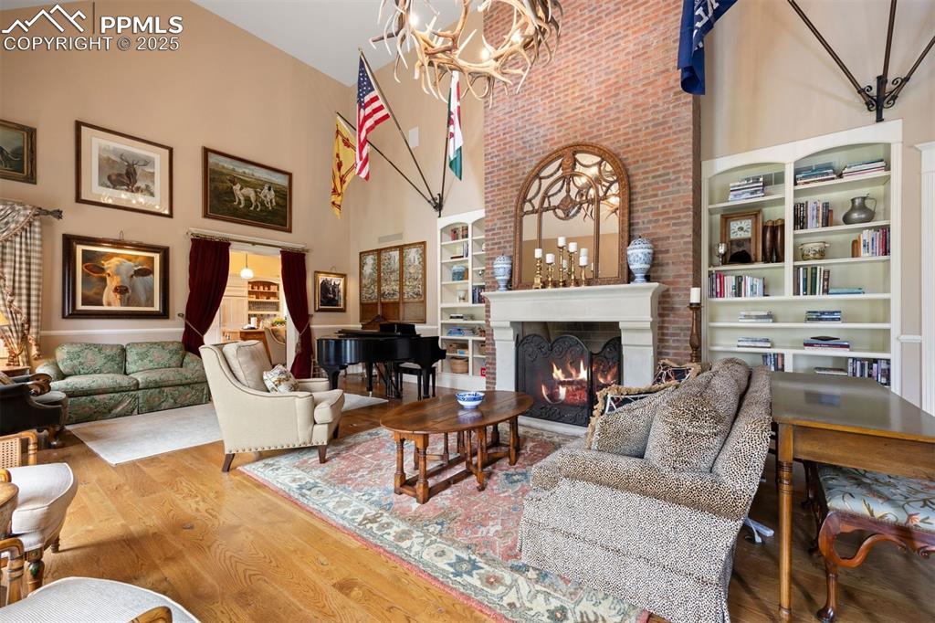 Image 7 of 49: A floor-to-ceiling brick fireplace with substantial cast stone mantel is th