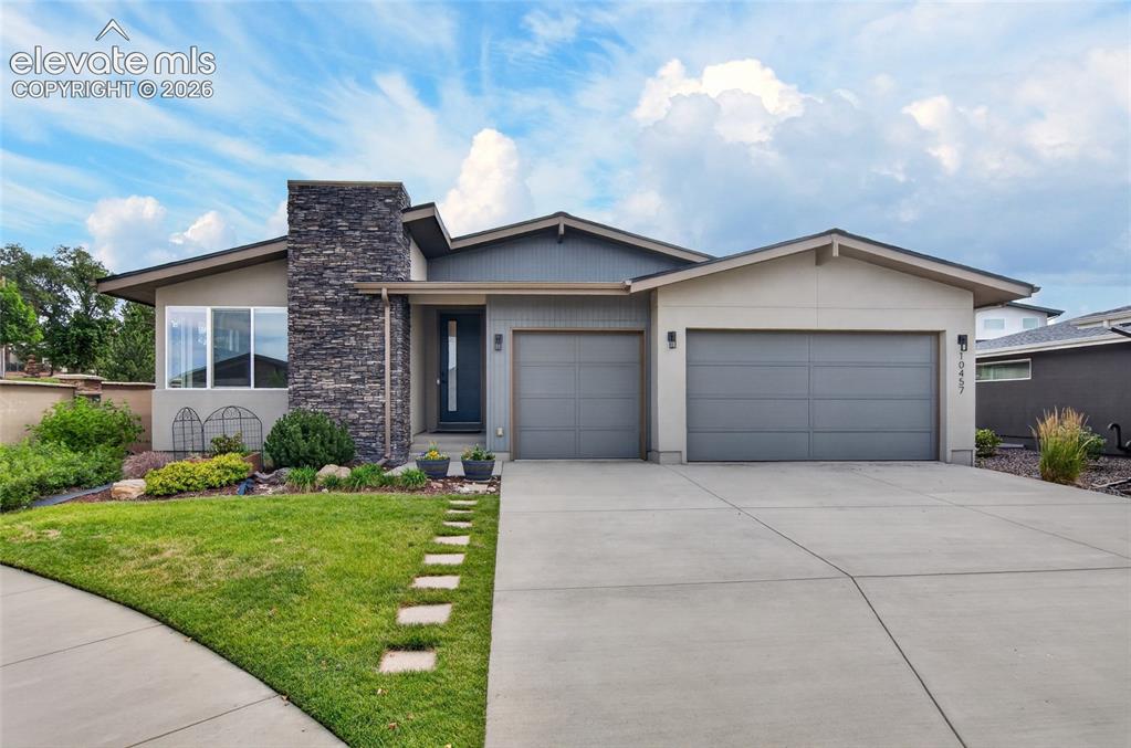 Image 1 of 50: Contemporary exterior featuring a stone accent column, four-car tandem gara