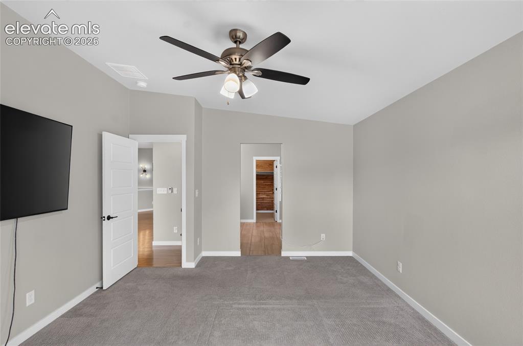Image 17 of 50: Master Bedroom featuring soft gray wall paint, gray carpet flooring, and a