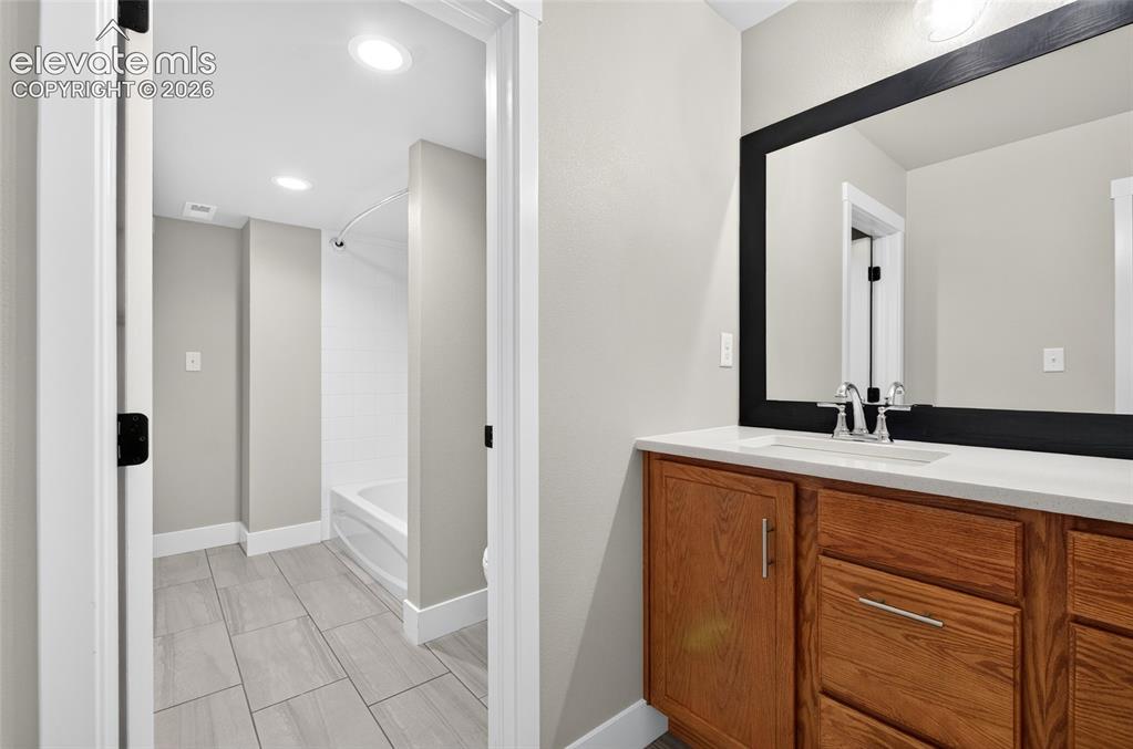 Image 23 of 50: Shared with main floor bedroom and library, Bathroom vanity featuring a qua