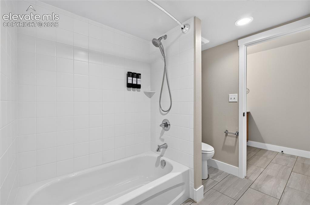 Image 24 of 50: Bathtub and shower combination featuring white subway tile surround, chrome