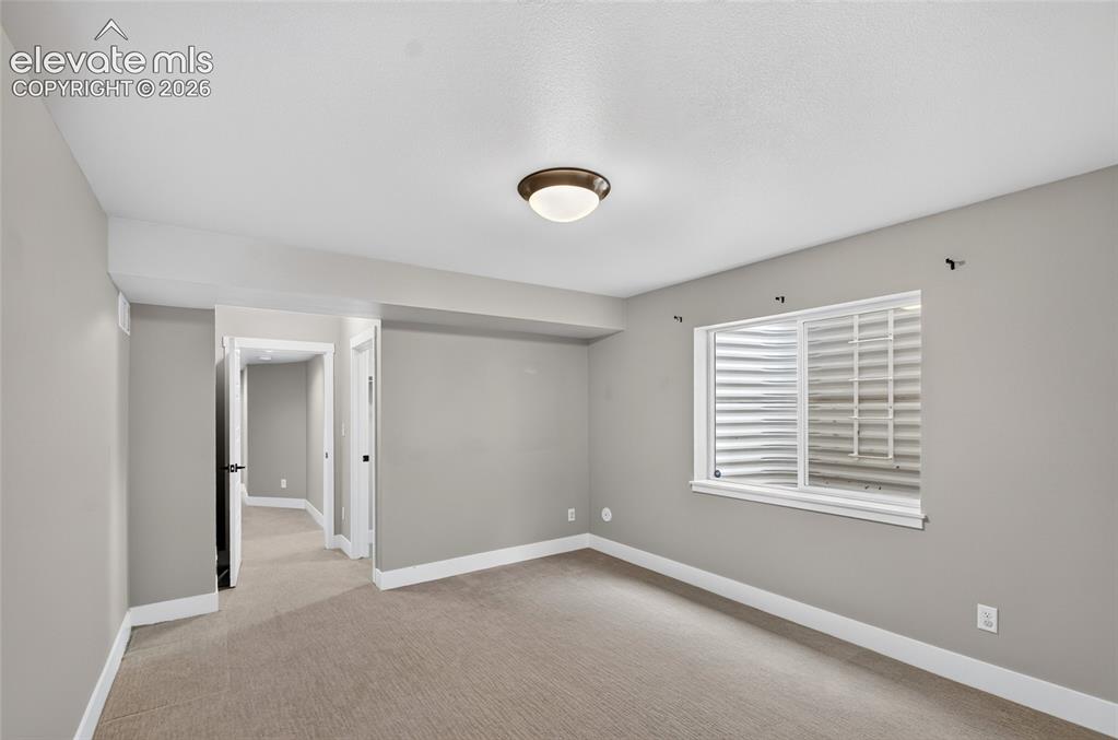 Image 39 of 50: Neutral tone walls with white baseboards, a flush-mount ceiling light, and
