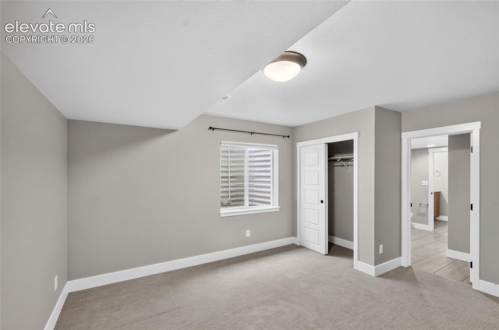Image 40 of 50: Carpeted room featuring light gray walls, white trim, a flush-mount ceiling