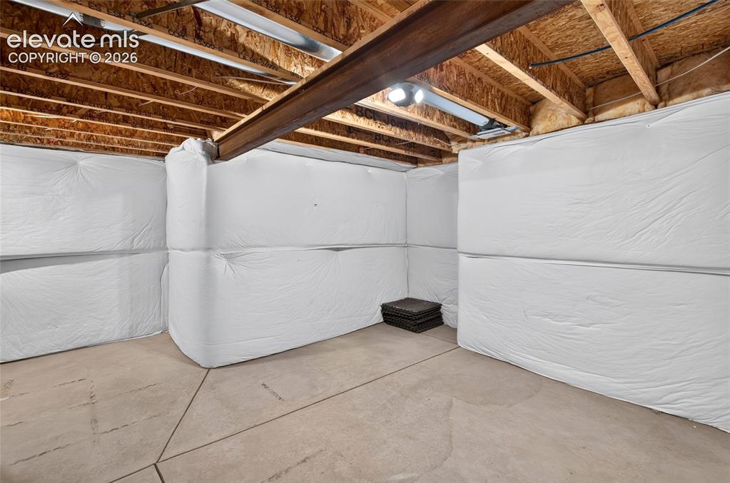 Image 41 of 50: Unfinished basement featuring exposed wood joists and a steel support beam