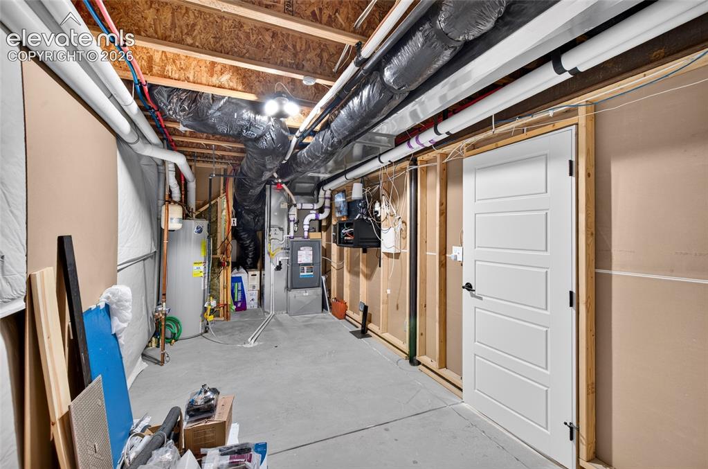 Image 42 of 50: Unfinished basement space featuring a concrete floor, exposed wood joists,