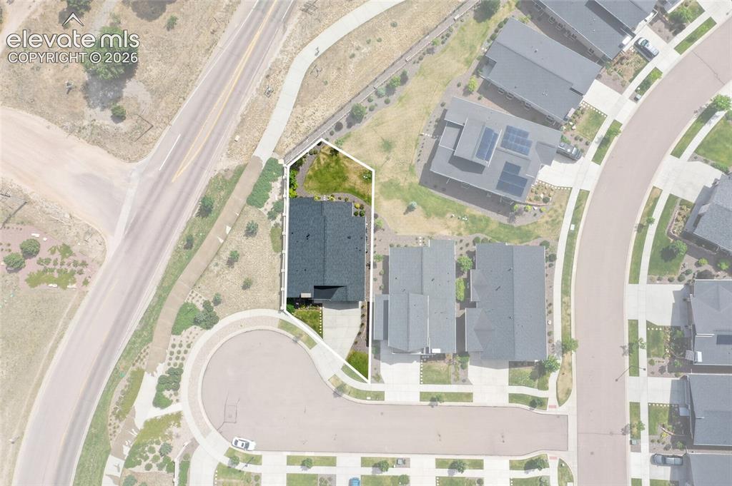 Image 47 of 50: Aerial view showcasing a residential property with a dark shingle roof and