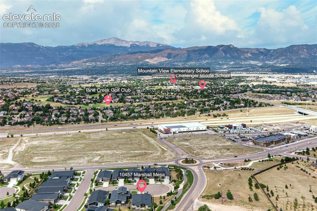 Image 49 of 50: Aerial overview showcasing the community with prominent mountain ranges for