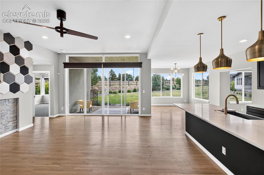 Image 6 of 50: view of center island kitchen on right and fireplace on left- outdoor patio
