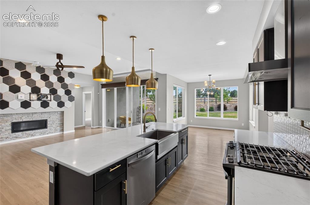 Image 7 of 50: Open-concept kitchen with a large island featuring a farmhouse sink, stainl