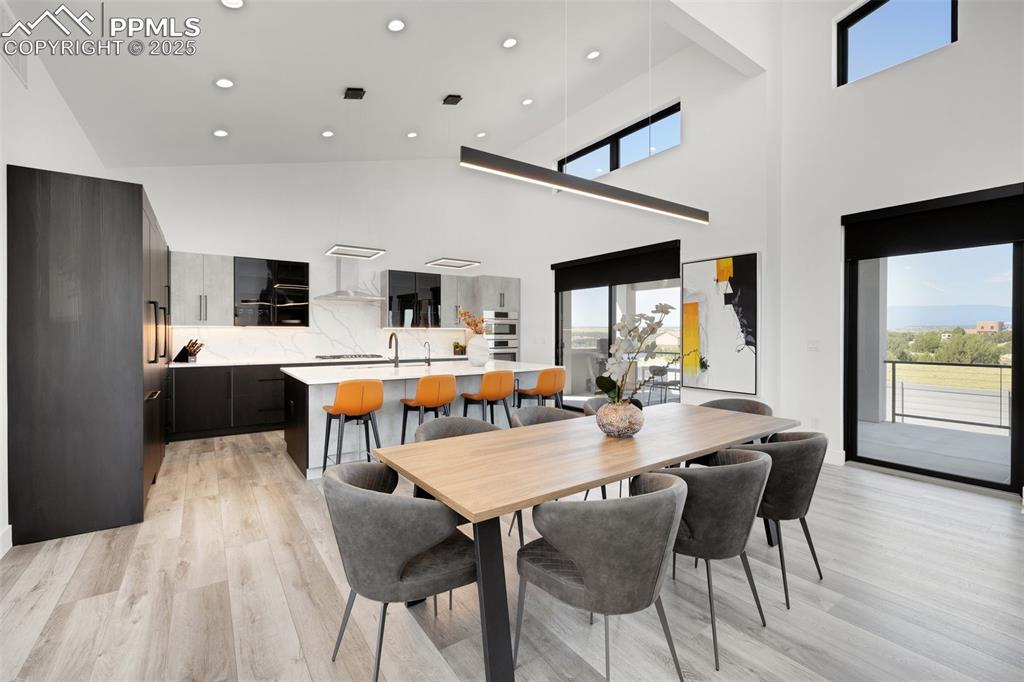 Image 20 of 50: Dining space with light wood-style flooring, recessed lighting, and a high