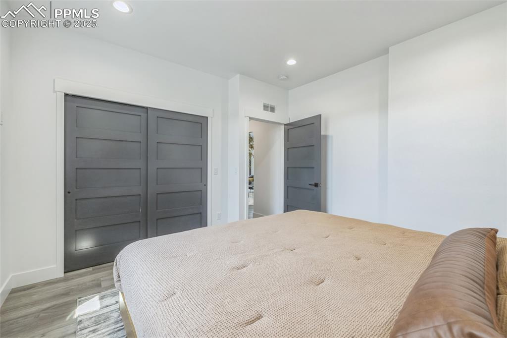 Image 25 of 50: Bedroom featuring light wood-style floors, recessed lighting, and a closet