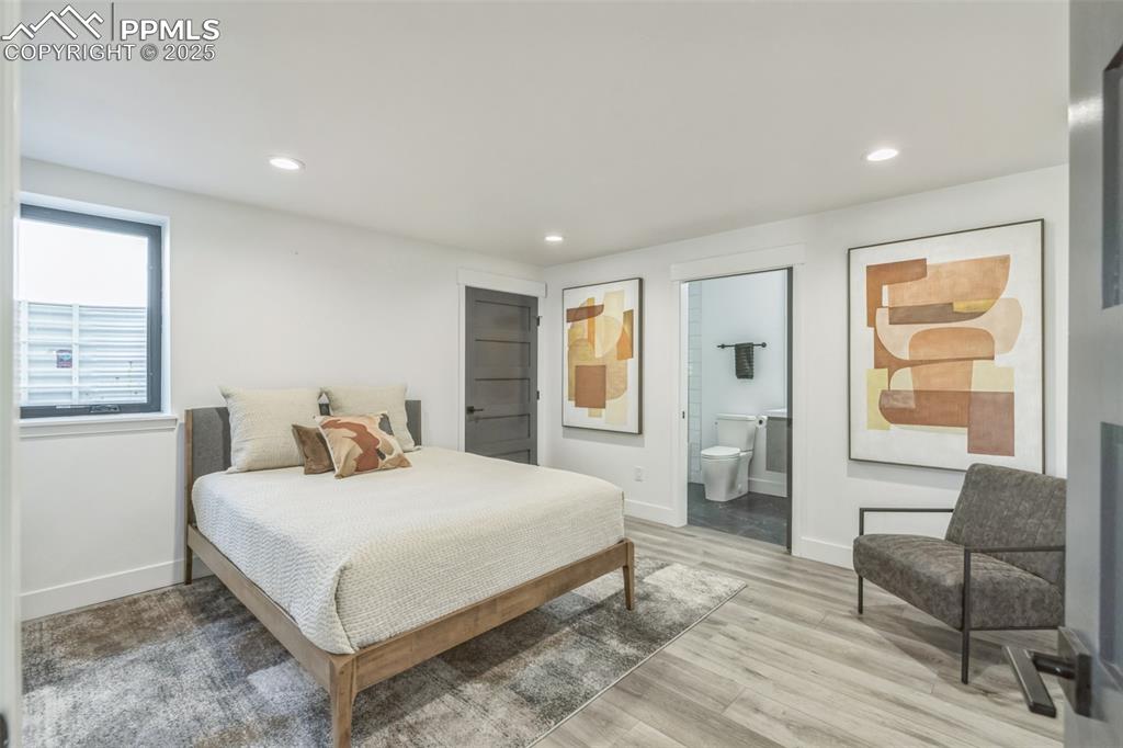 Image 29 of 50: Bedroom featuring recessed lighting, light wood finished floors, and ensuit