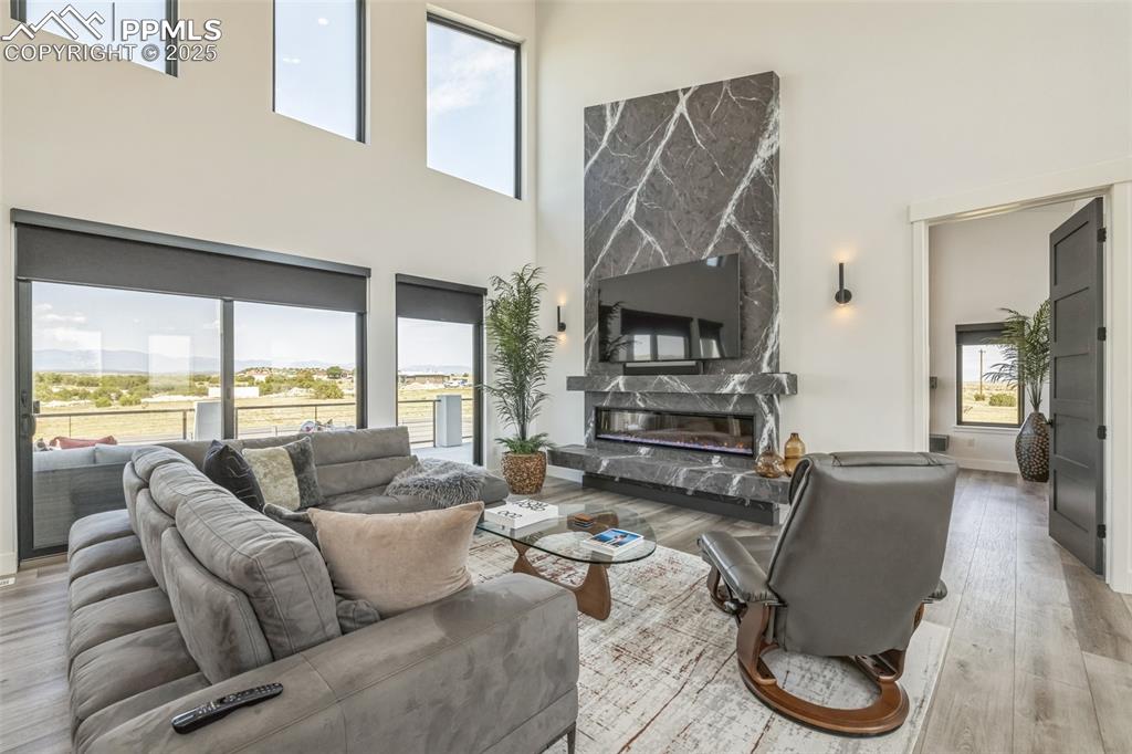 Image 5 of 50: Living room featuring light wood-style floors, a high end fireplace, and a