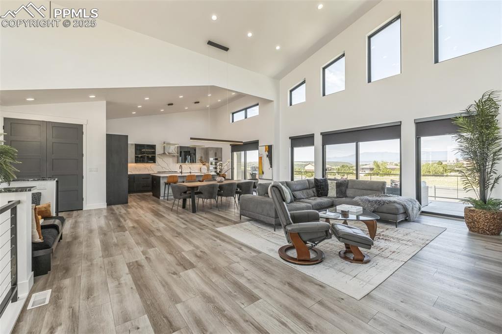 Image 6 of 50: Living area with recessed lighting, light wood finished floors, and vaulted