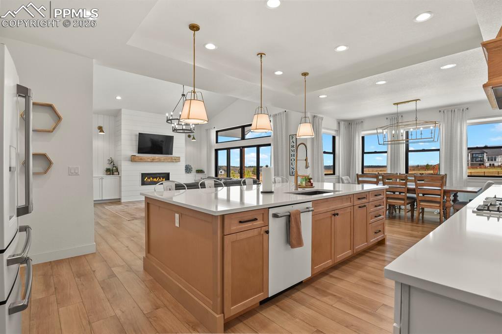 Image 11 of 47: Two tone kitchen with a large island with sink, light wood-style flooring, 