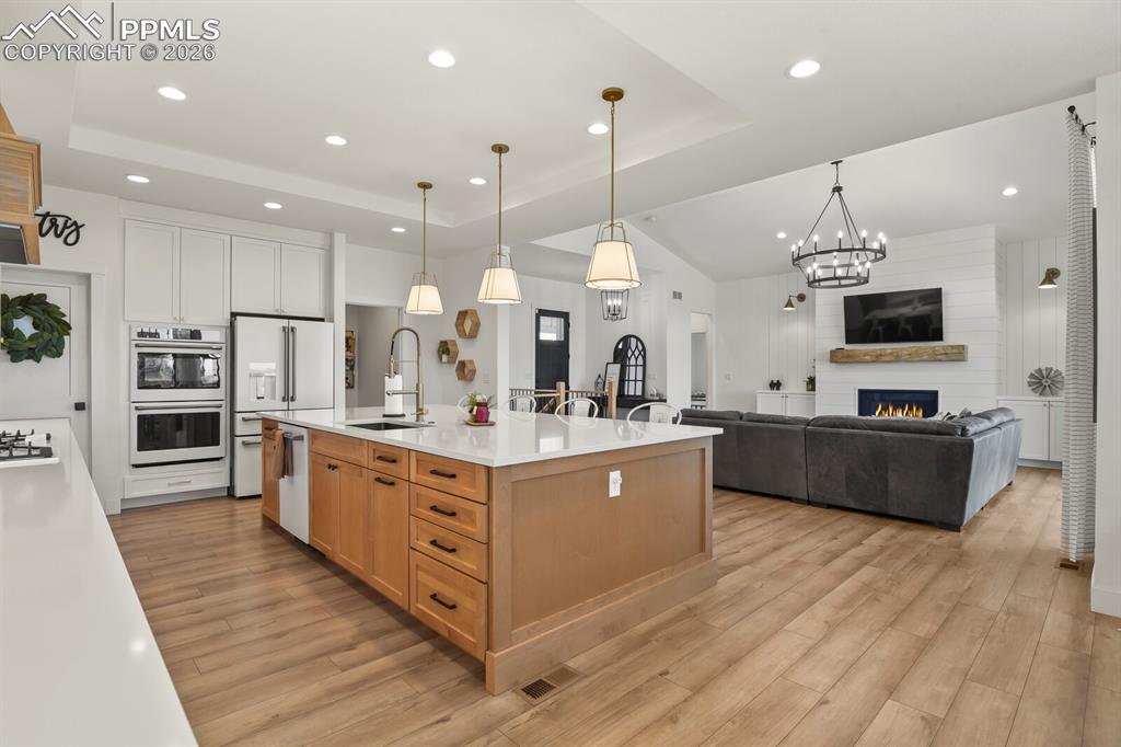Image 12 of 47: Two tone kitchen featuring two tone cabinetry, a spacious island, open floo
