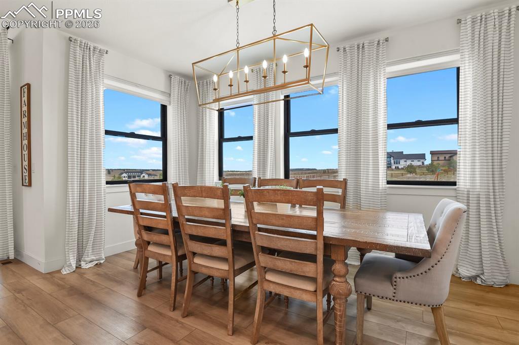Image 14 of 47: Dining room with light wood-type flooring and a chandelier