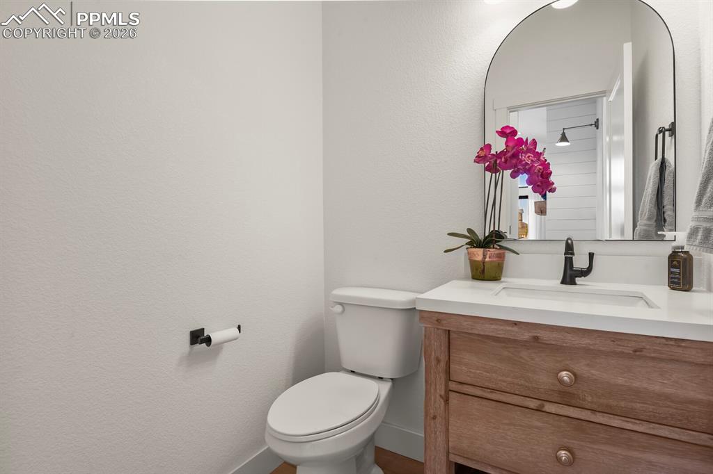 Image 17 of 47: Half bathroom with vanity and a textured wall
