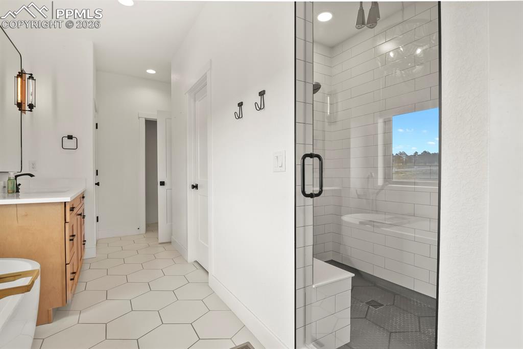 Image 23 of 47: Full bathroom featuring vanity, a shower stall, light tile patterned floors