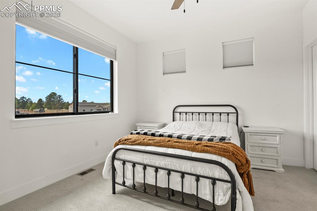 Image 24 of 47: Bedroom featuring light colored carpet and a ceiling fan