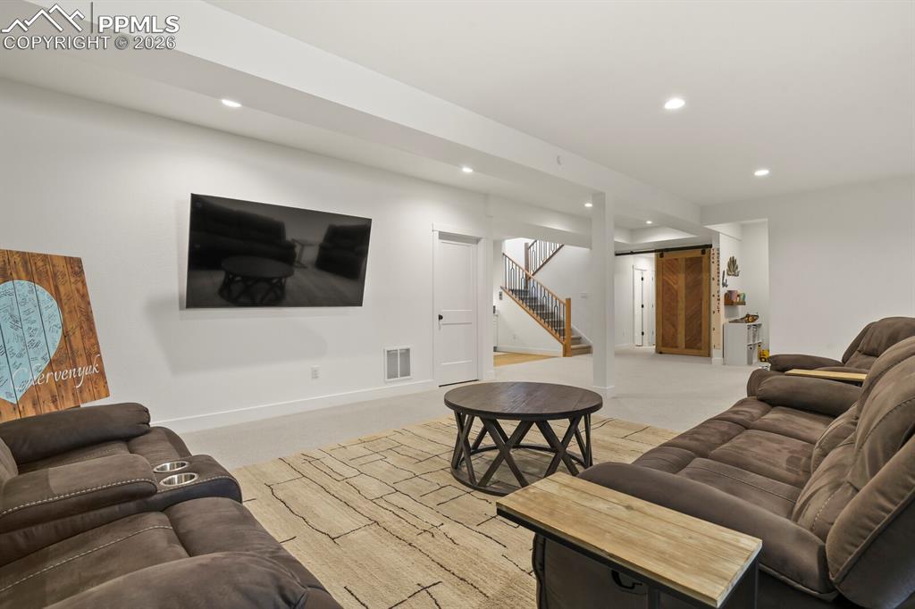 Image 30 of 47: Living area featuring light colored carpet and recessed lighting