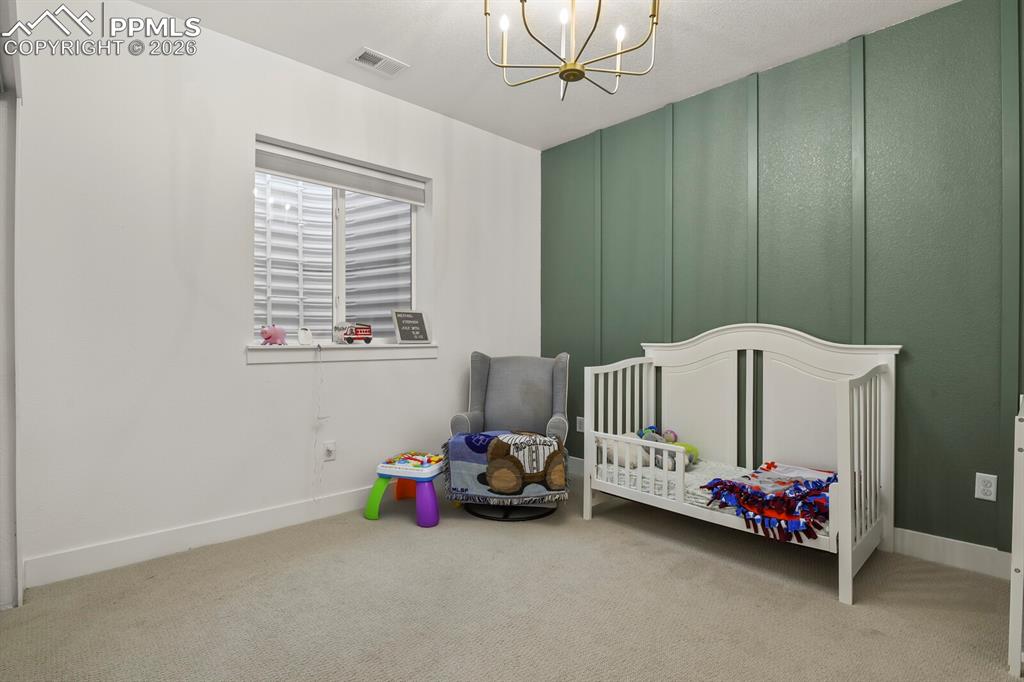 Image 33 of 47: Unfurnished bedroom with a chandelier, a decorative wall, light colored car