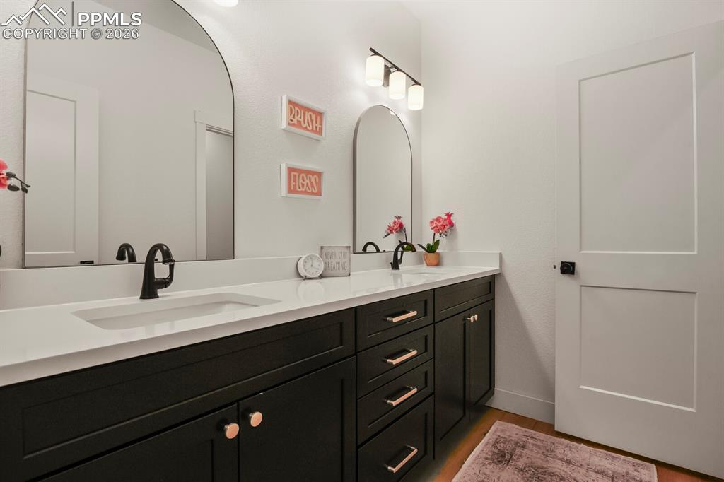 Image 35 of 47: Bathroom with double vanity and baseboards
