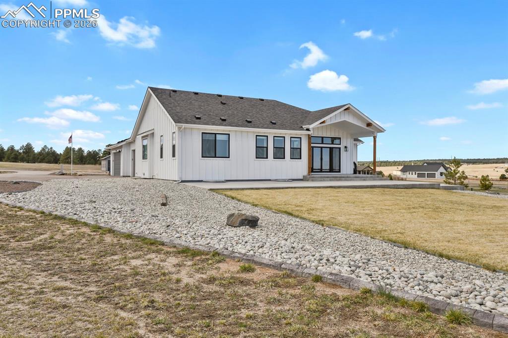 Image 40 of 47: View of front facade with a front yard and roof with shingles