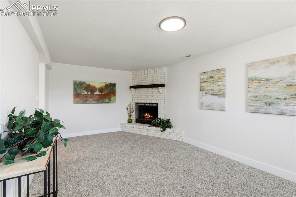 Image 20 of 32: Family Room with Wood-Burning Brick Fireplace