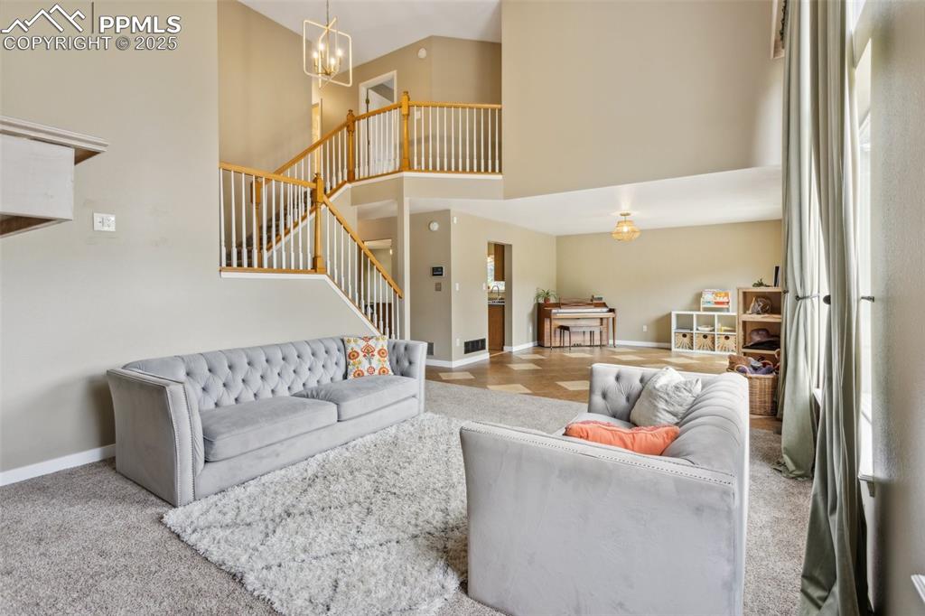 Image 11 of 37: Great room, soaring windows, and a gas fireplace