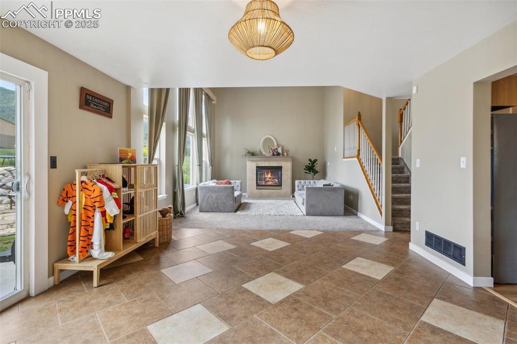 Image 12 of 37: Great room, soaring windows, and a gas fireplace. Dining room is currently