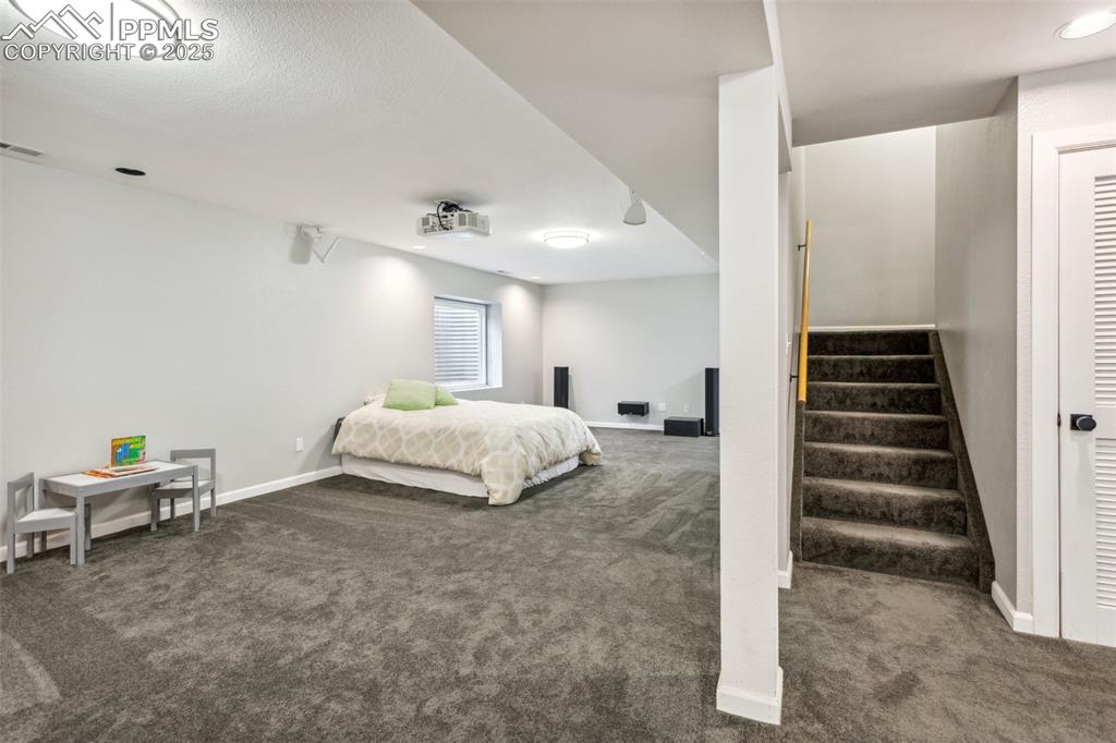 Image 24 of 37: Finished basement with a full bathroom, wet bar, and theater projector.